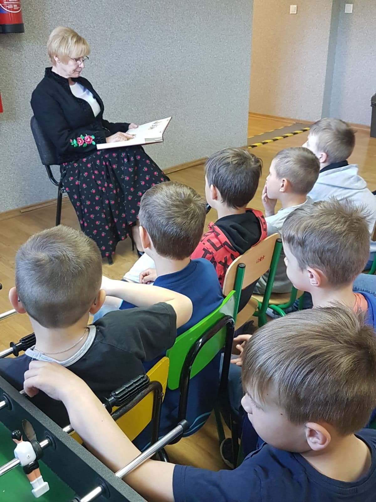 Zdjęcie przedstawia Panią Włądysławę Omylak czytającą uczniom klas I-III bajkę pt. "Trzy Świnki".