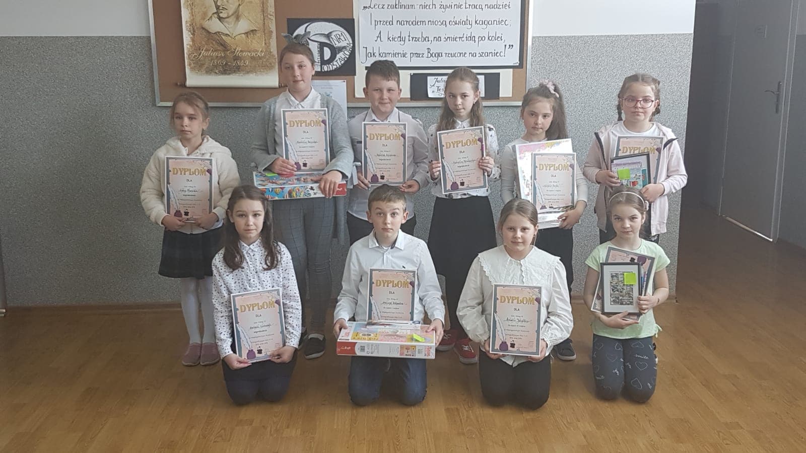 Zdjęcie przedstawia uczniów Szkoły Podstawowej Nr 1, uczestników Międzyszkolnego Konkursu Ortograficznego wraz z dyplomami i nagrodami rzeczowymi.