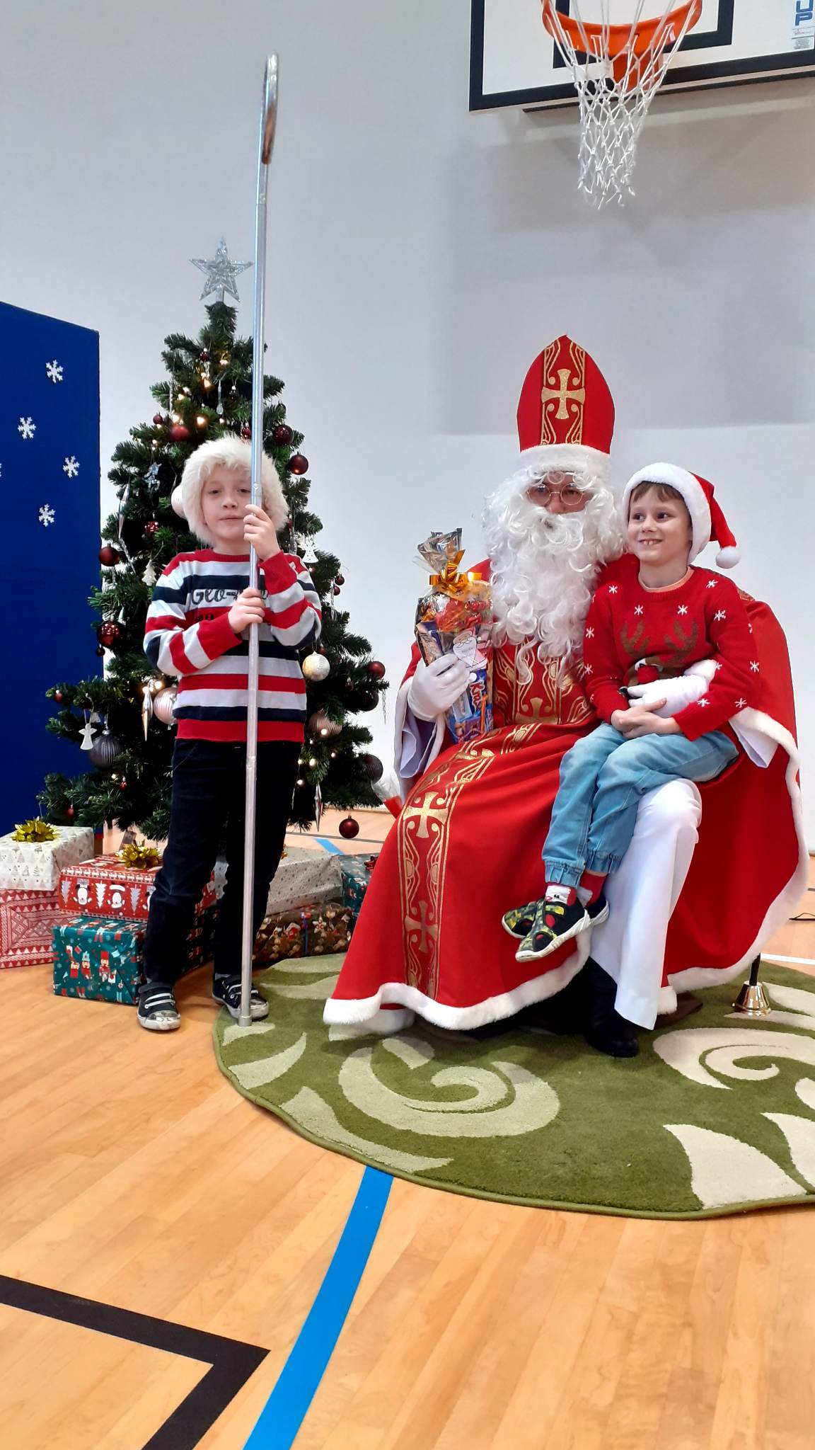 Zdjęcie przedstawia Świętego Mikołaja z dzieckiem na kolanach.