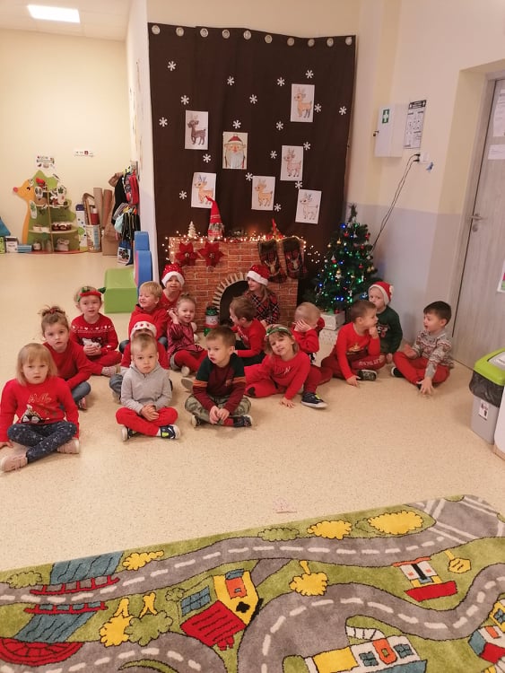 Grupa kilkunastu uczniów oddziału przedszkolnego oczekująca na przyjście Świętego Mikołaja