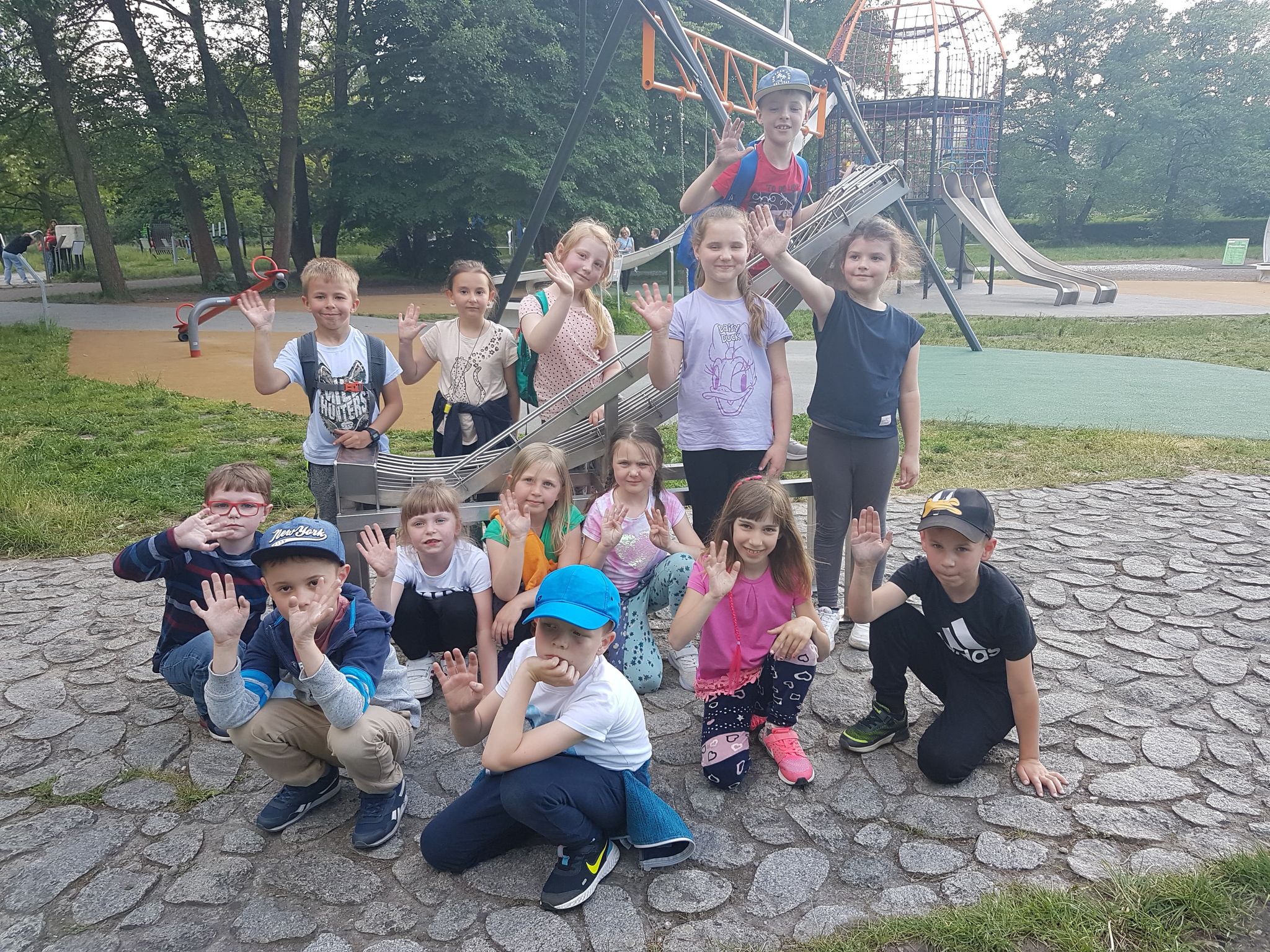 Zdjęcie przedstawia grupę kilkunastu uczniów w Ogrodzie Doświadczeń w Krakowie.