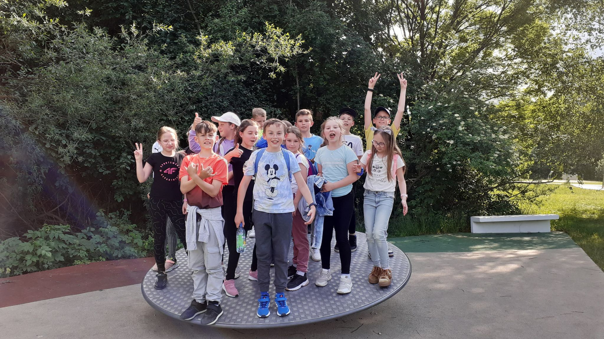 Zdjęcie przedstawia grupę kilkunastu uczniów stojących na ruchomym kole w Ogrodzie Doświadczeń w Krakowie 