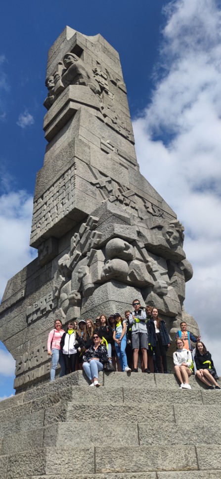 Zdjęcie przedstawia uczniów obok pomnika na Westerplatte.